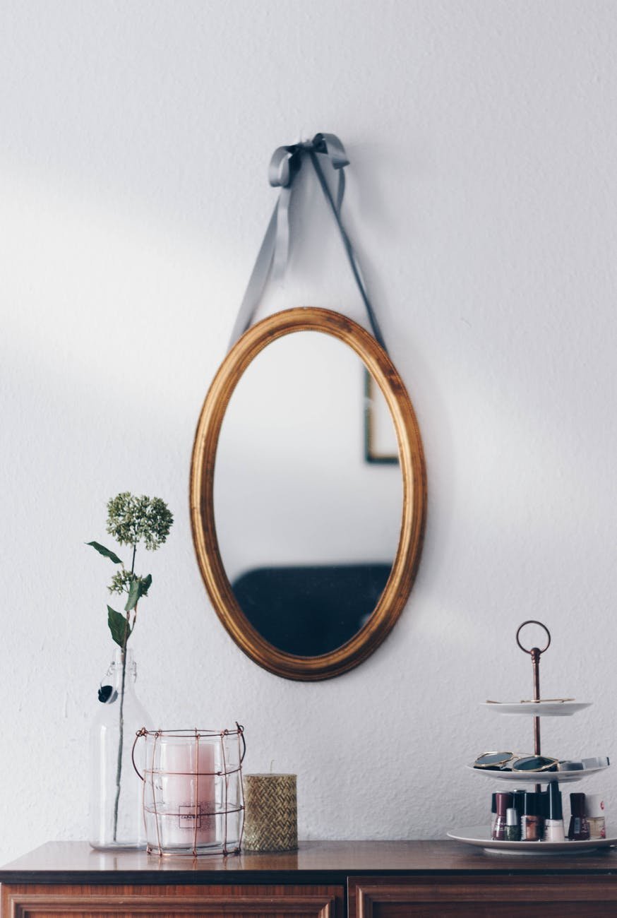 oval brown wooden framed hanging mirror