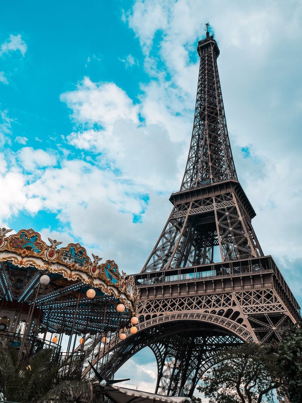low angle photo of the eiffel tower with carousel in the foreground